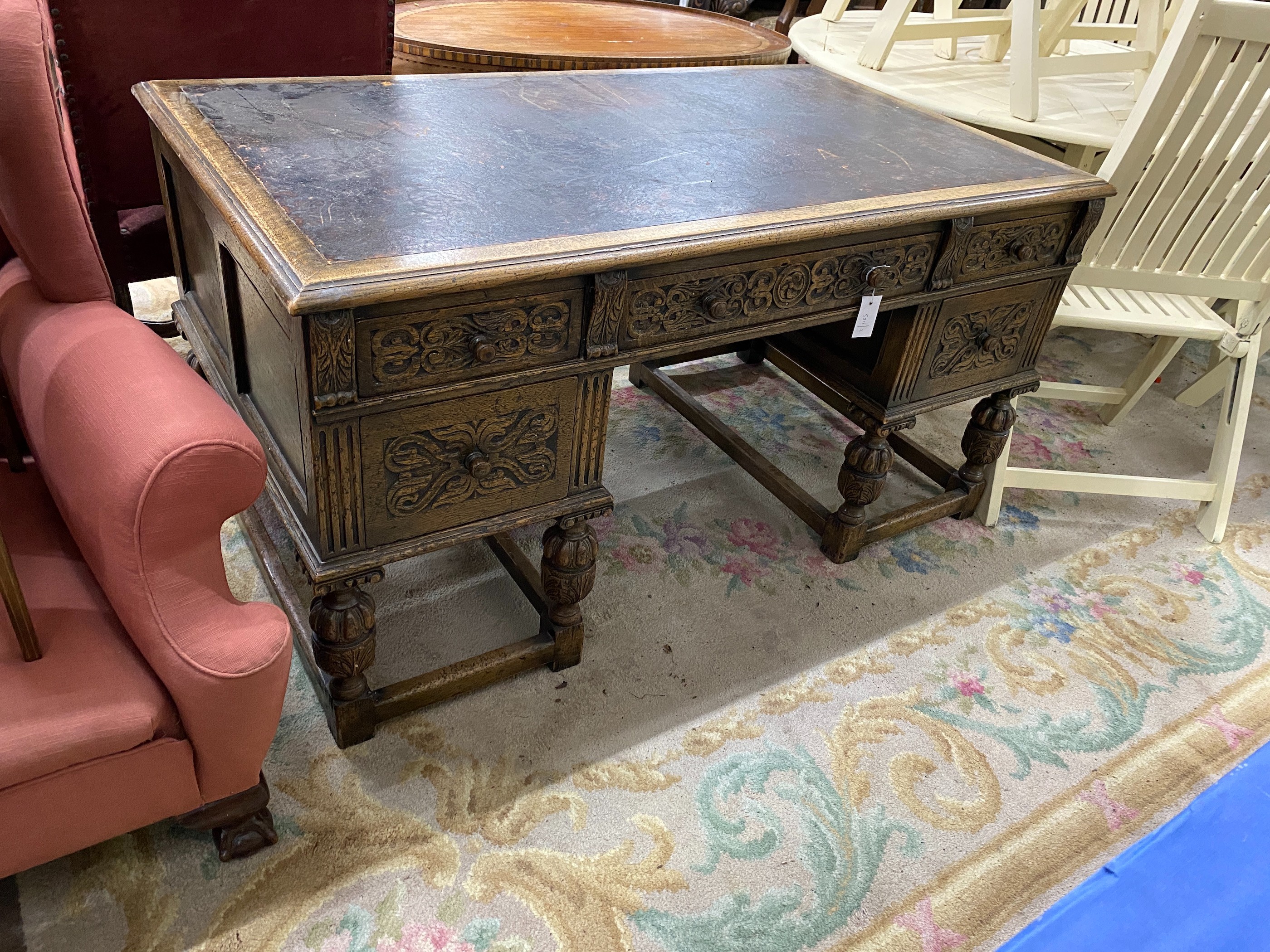 A 1920's Jacobean revival carved oak five drawer kneehole desk, length 144cm, depth 83cm, height 75cm